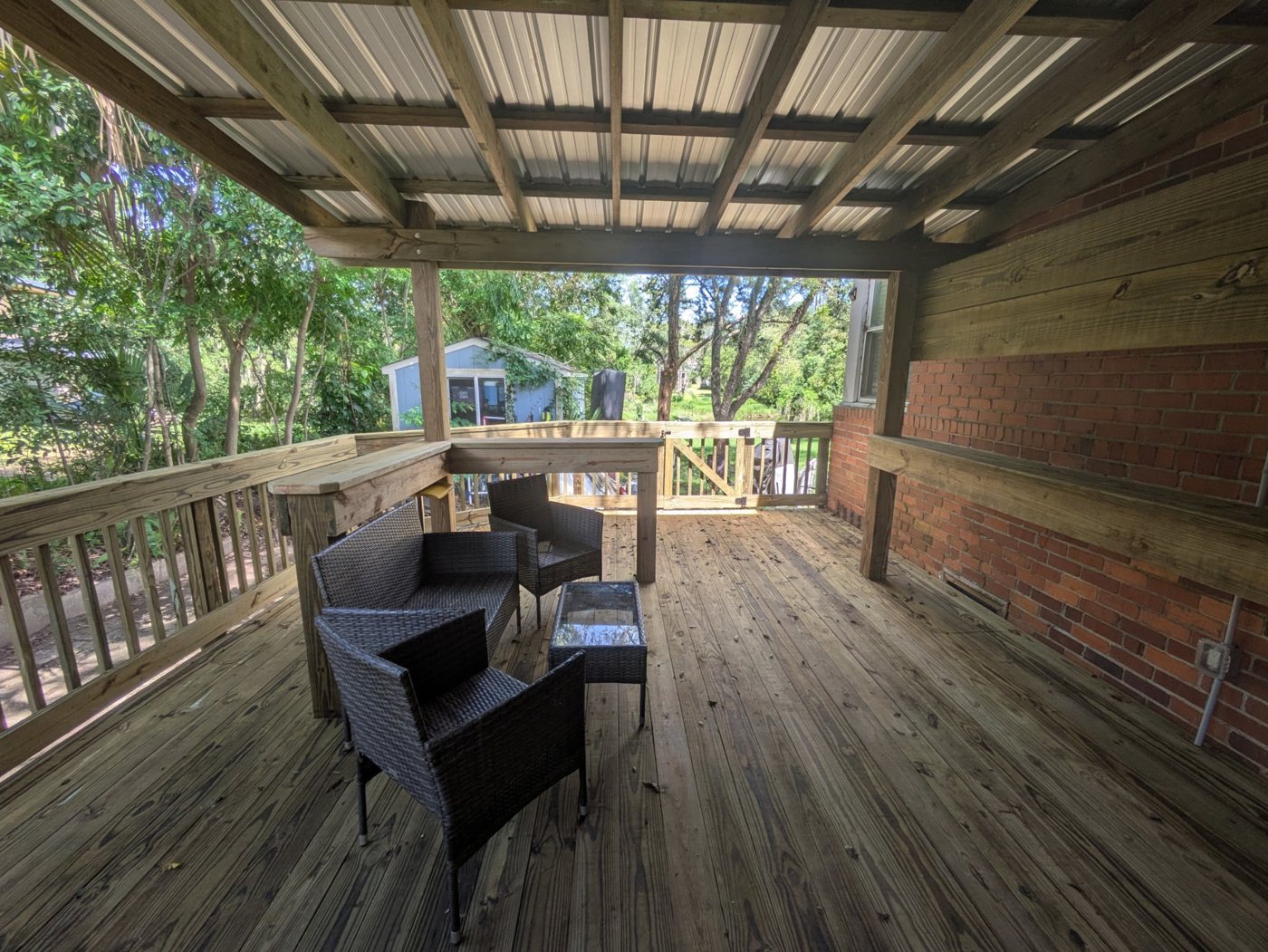 Deck project after — Overgrown paver patio transformed into a full covered deck with a metal roof — Jacksonville FL by P1Mitigators