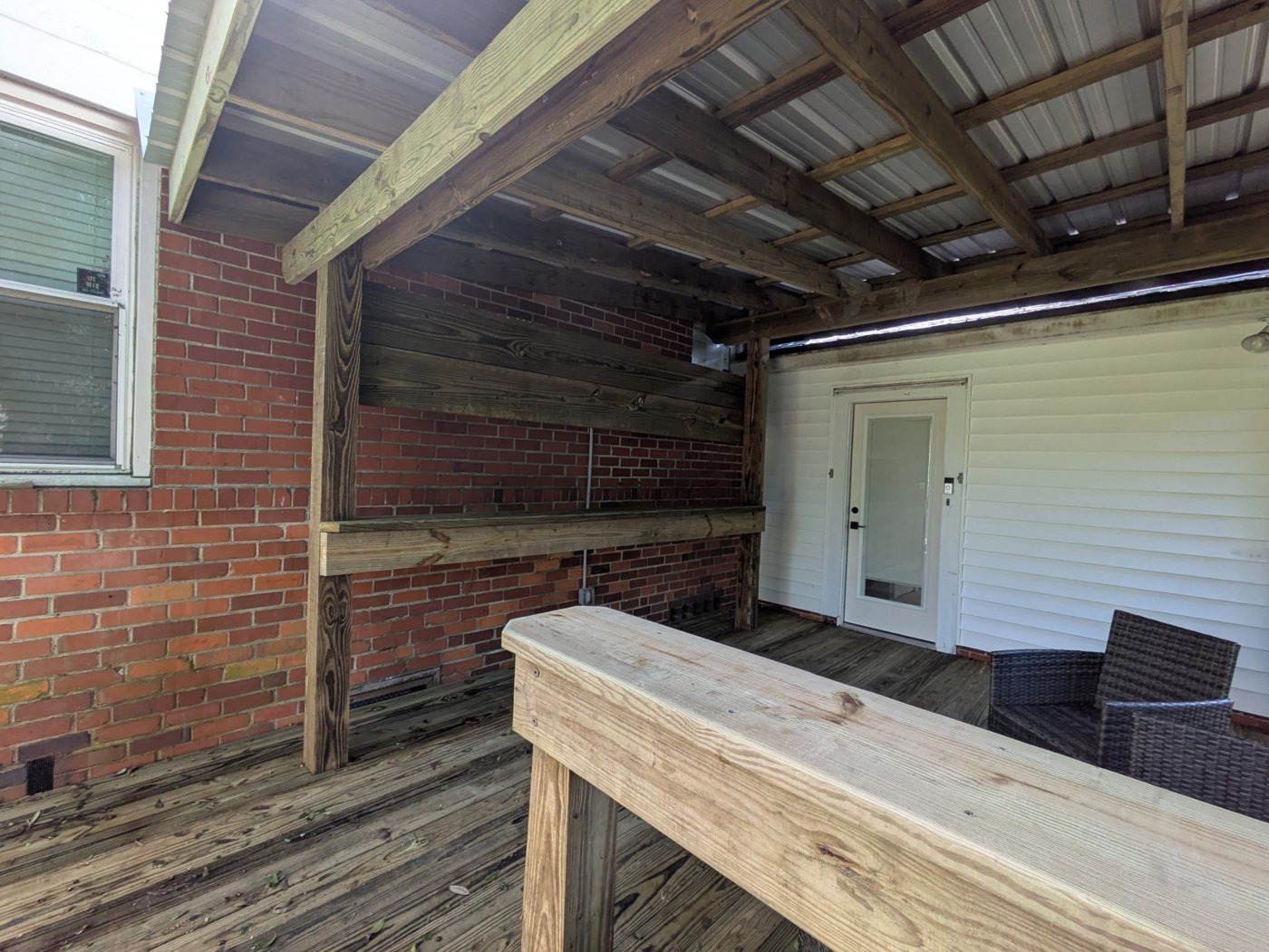 Deck project after — Cluttered back corner rebuilt into a shaded outdoor living space — Jacksonville FL by P1Mitigators