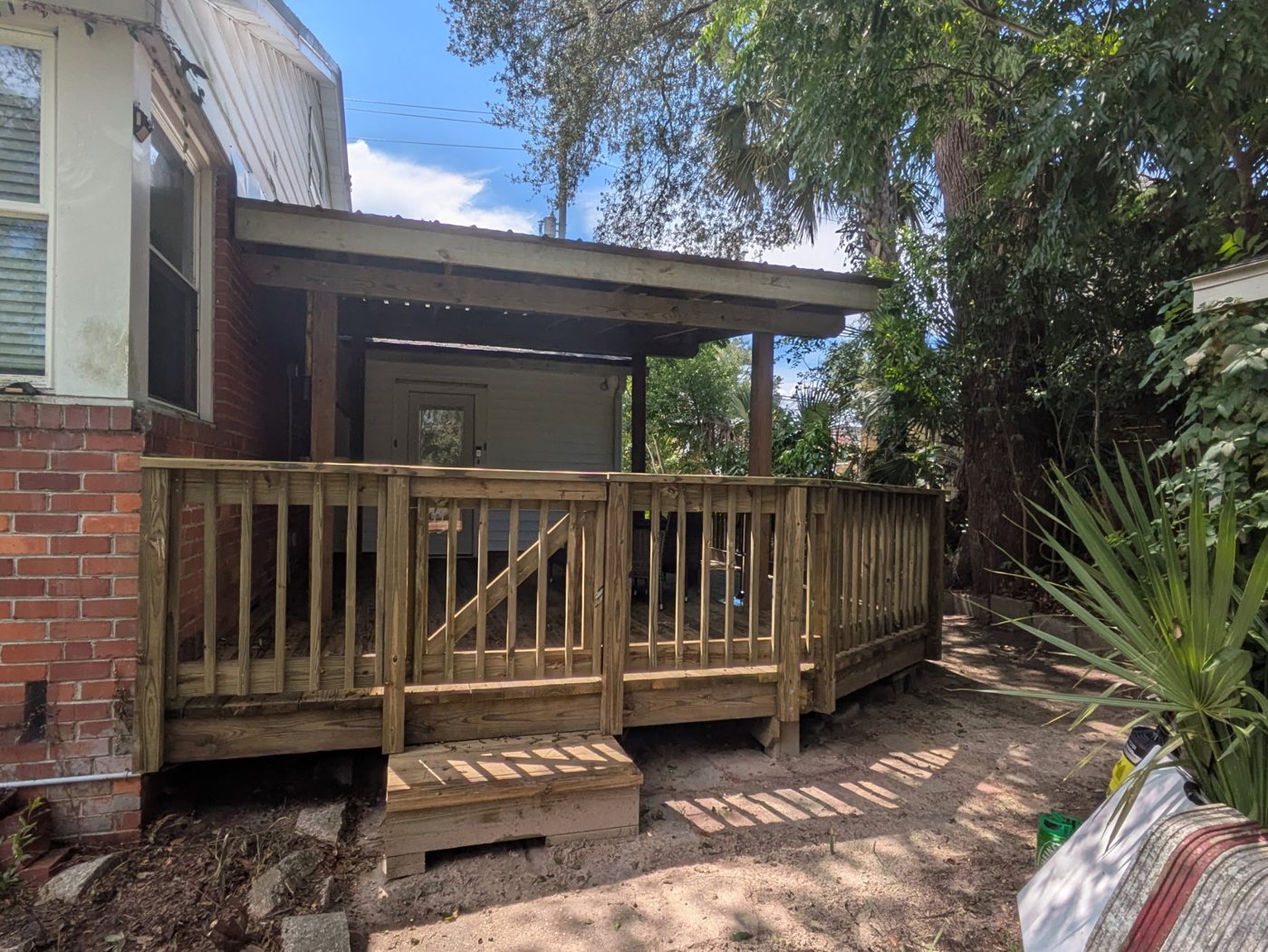 Deck project after — Weathered exterior reworked into a comfortable covered lounge deck — Jacksonville FL by P1Mitigators