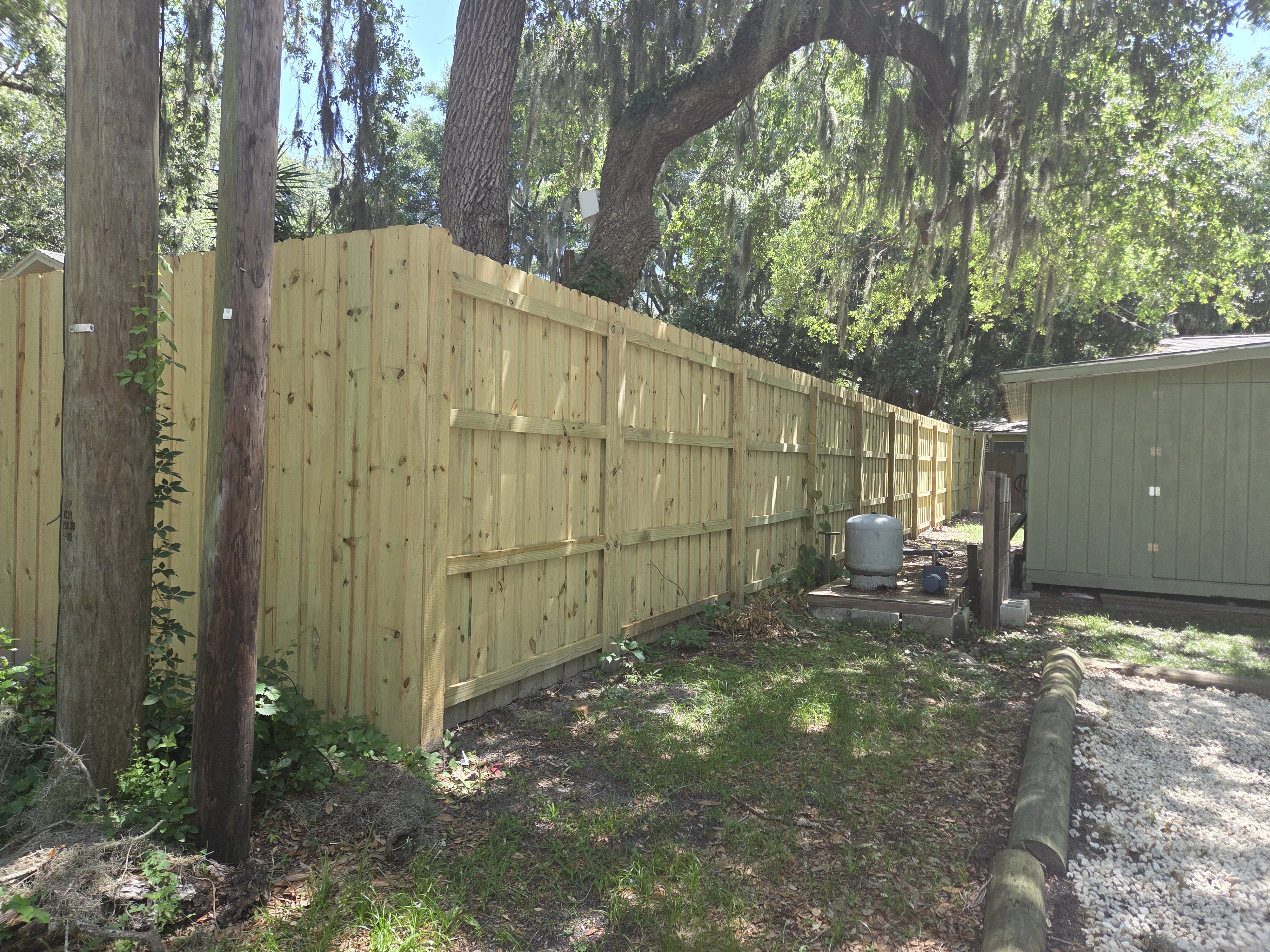 8-foot board on board fence back view with utility poles — full property line fencing Jacksonville FL