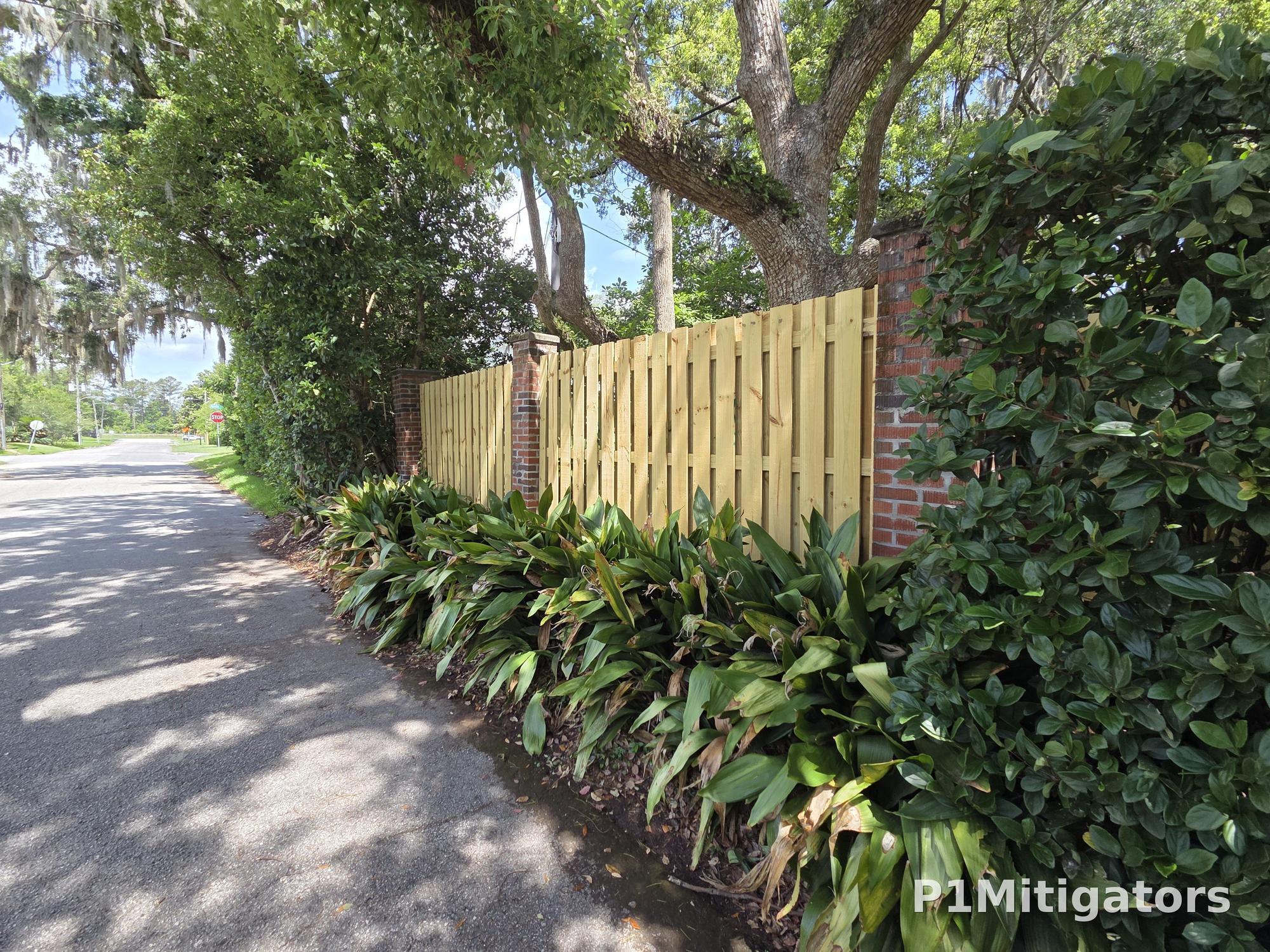 Shadowbox fence full run with brick pillars and mature oaks