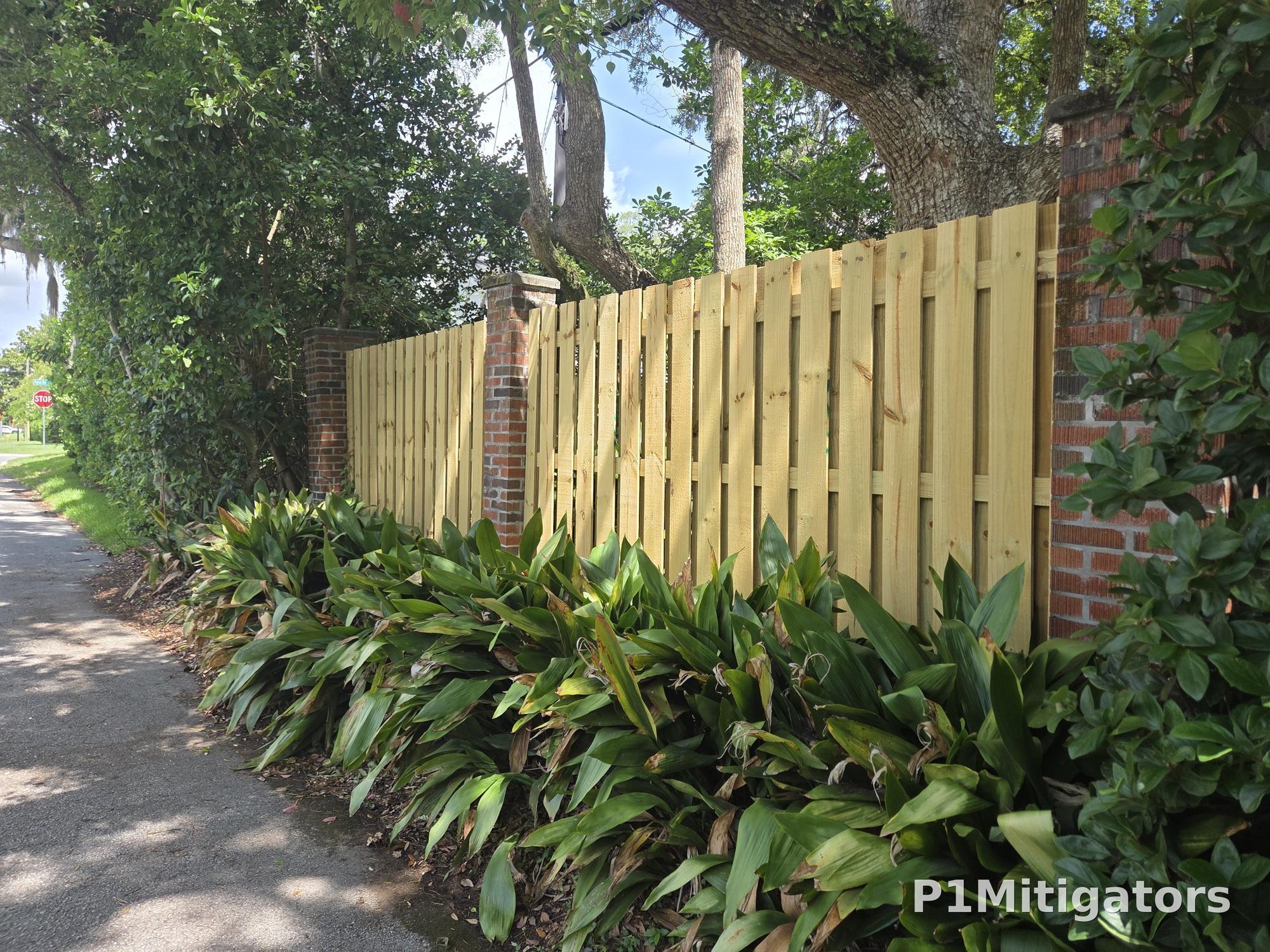 Shadowbox wood fence streetview — brick columns with landscaping