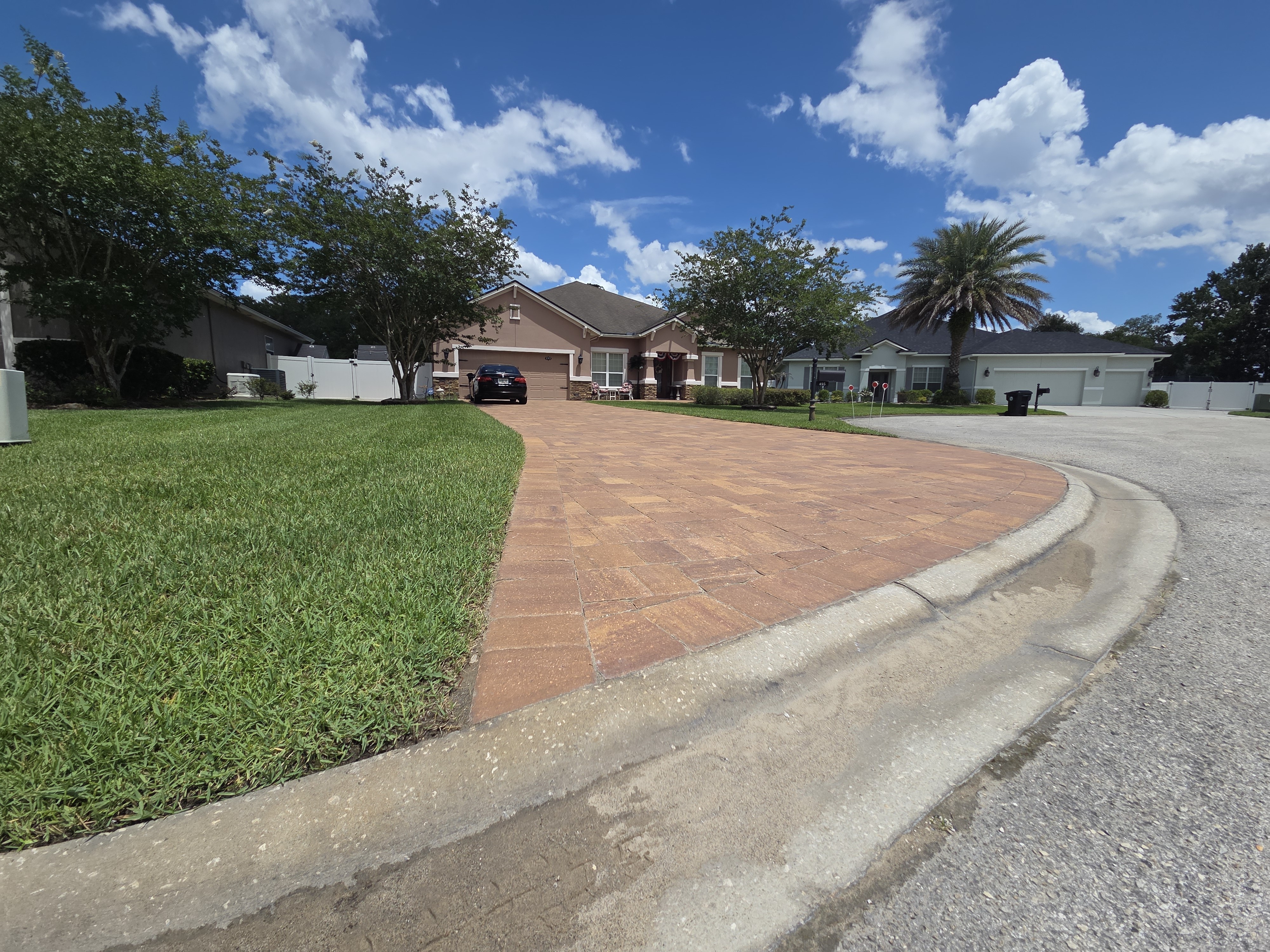 Curved paver driveway wider angle — full driveway arc with lawn and landscaping