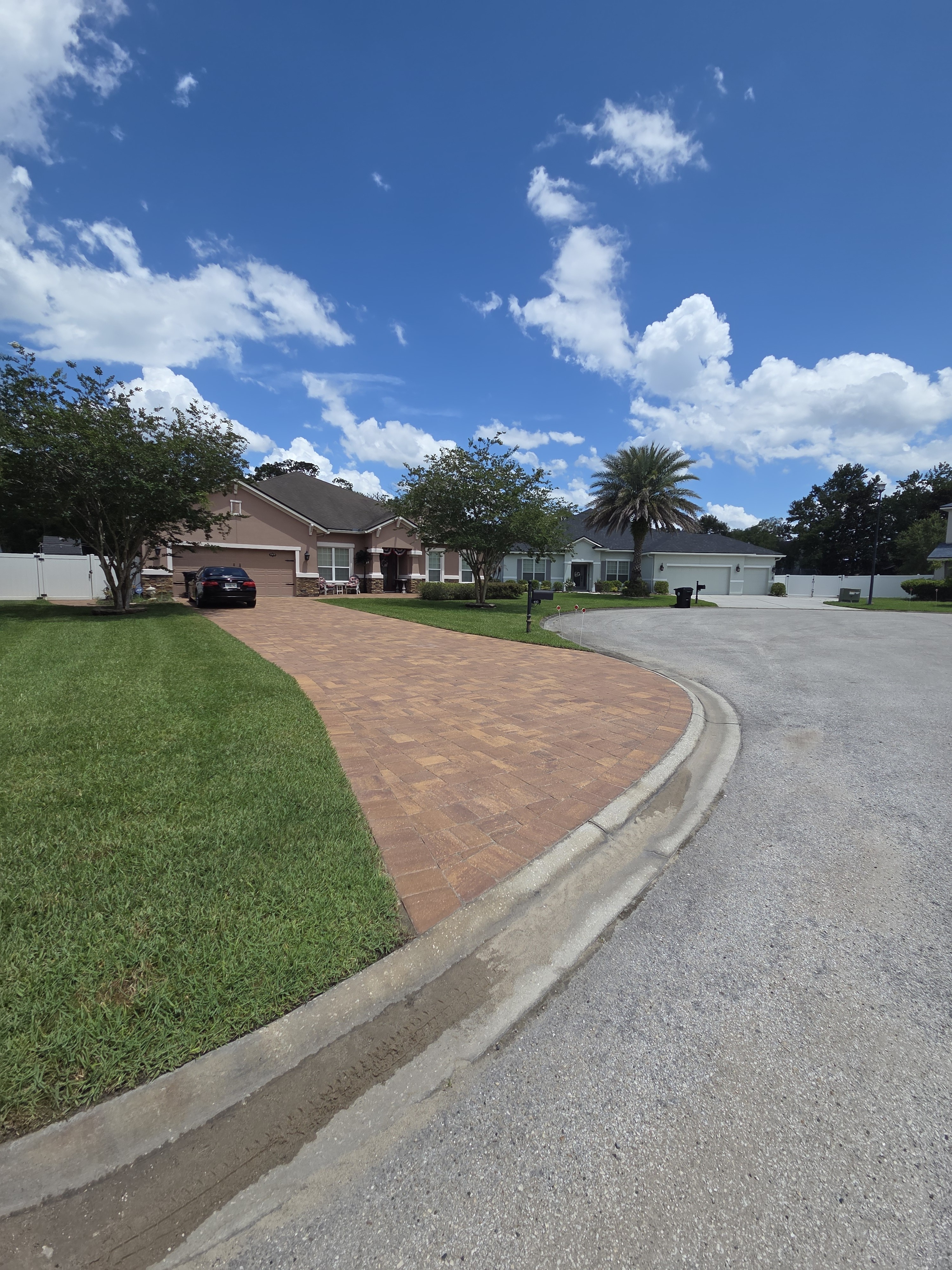 Curved brick paver driveway portrait view — elegant sweeping curve with contrasting border
