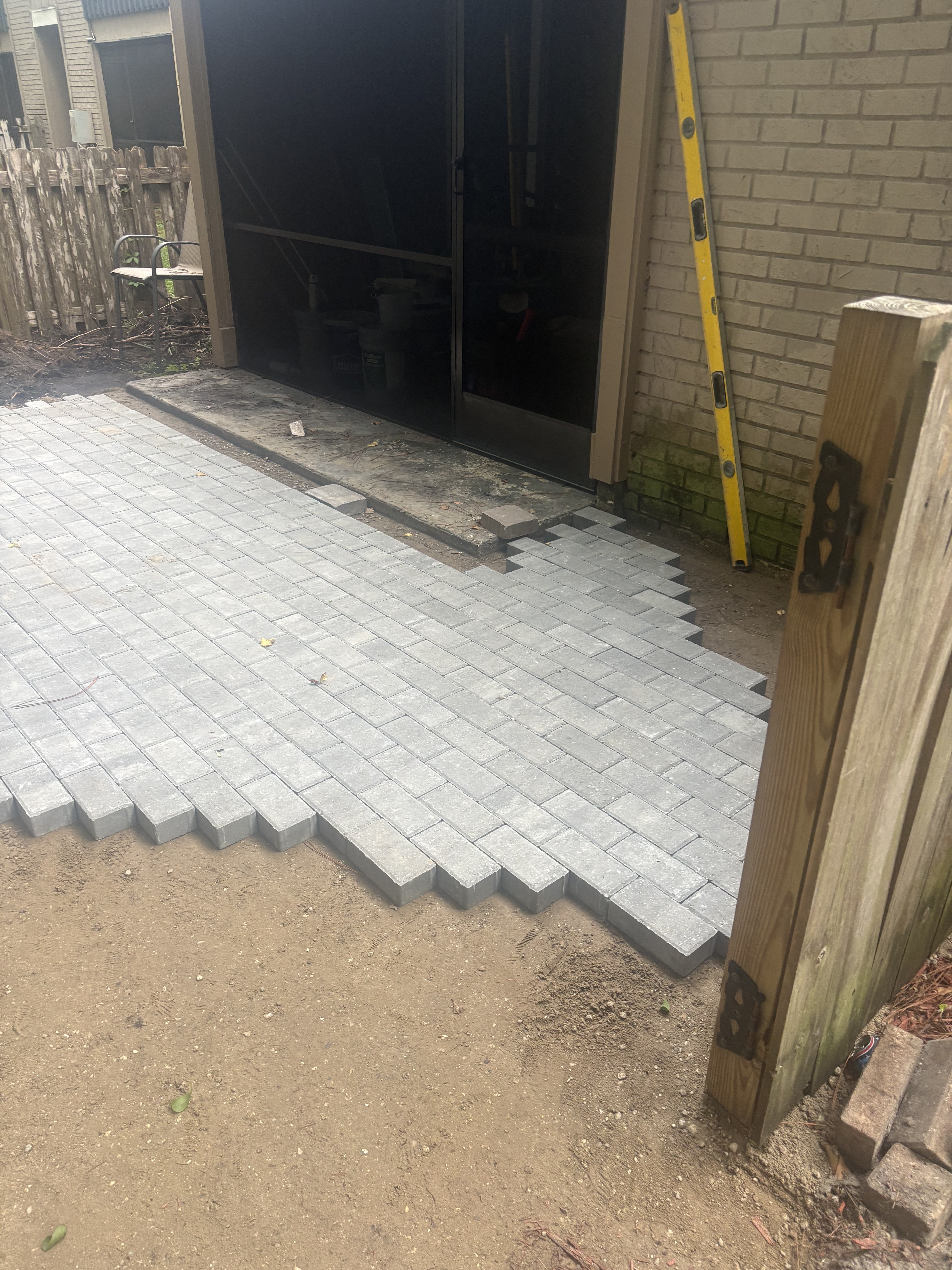 Paver driveway progress — fitting pavers around garage opening