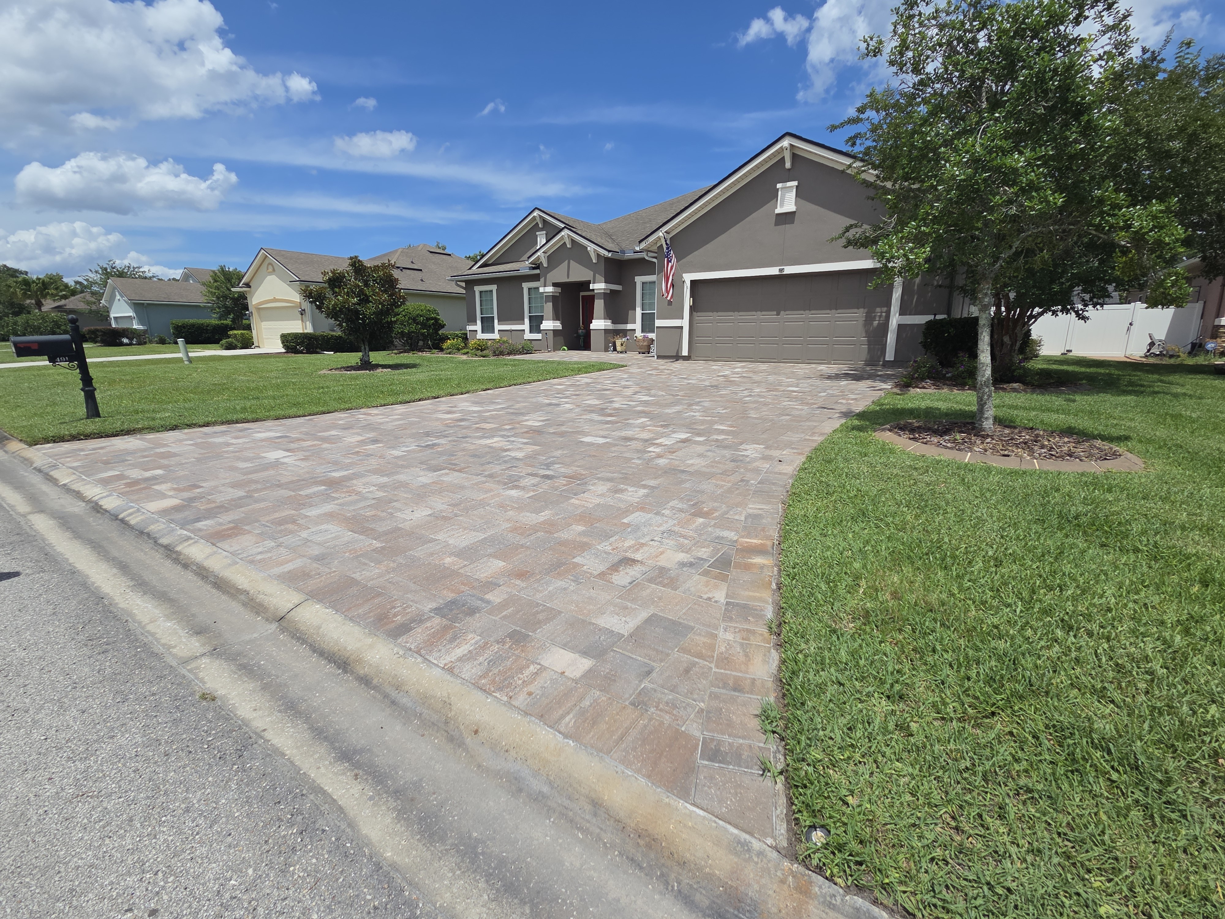 Completed brick paver driveway — straight run viewed from street