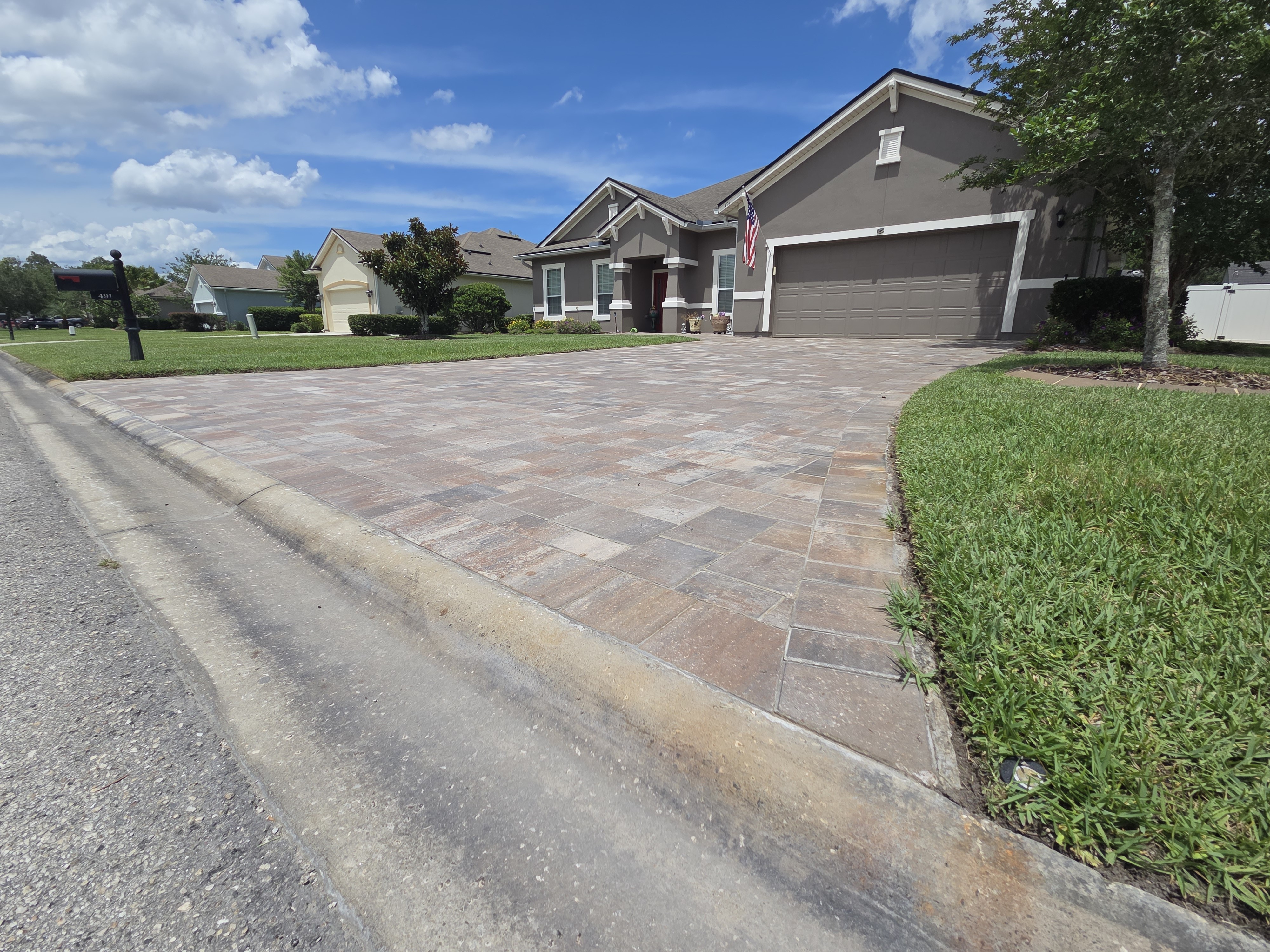 Brick paver driveway wide street view — full property frontage with herringbone pattern