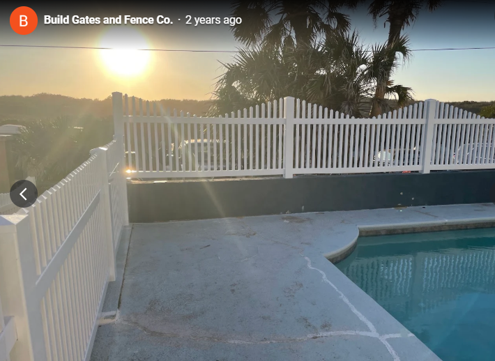 White picket fence around pool by Build Gates and Fence Co.